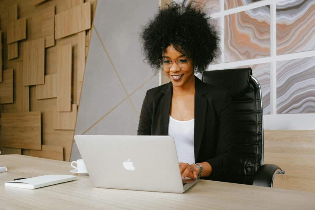 woman in black blazer using a laptop
