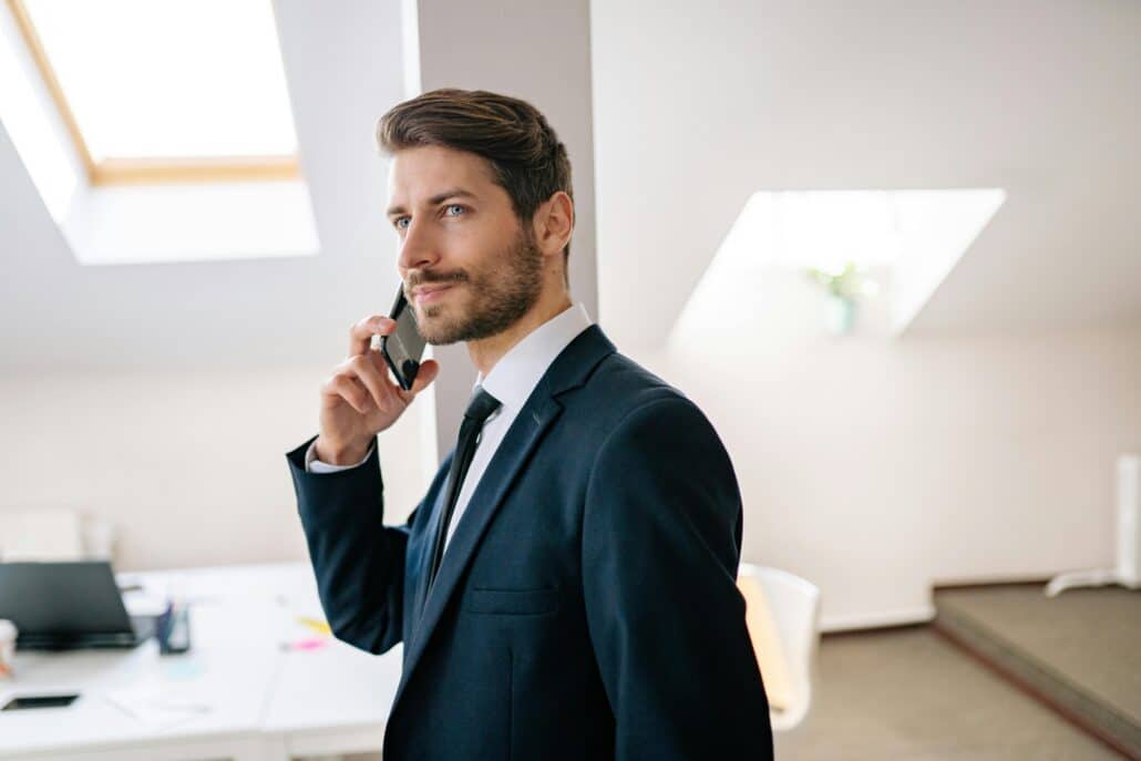 a man in a suit speaking on a cellphone