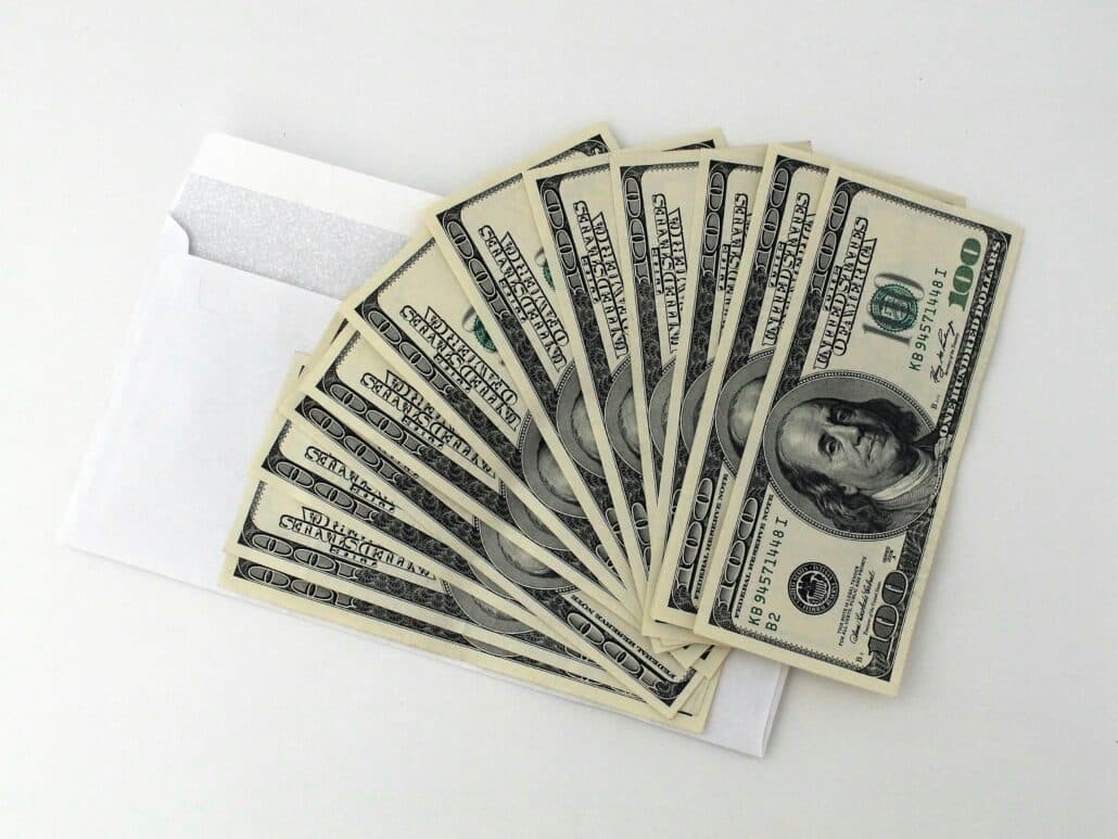 cash spread out over a white envelope