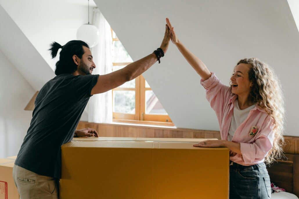 two people high-fiving over moving boxes