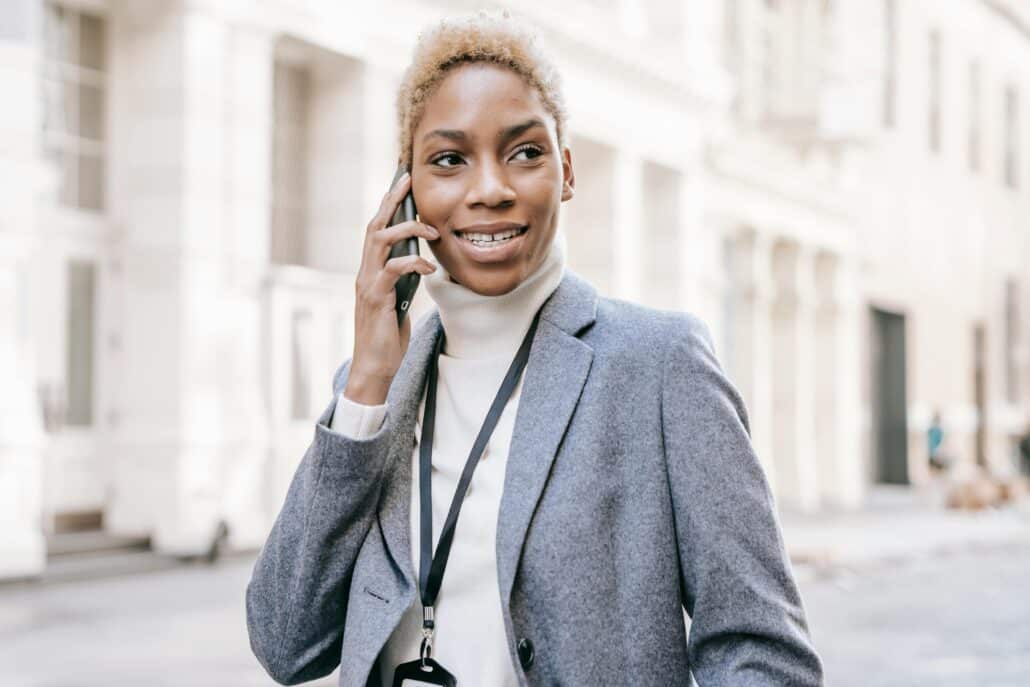 woman in a blazer on the phone outside